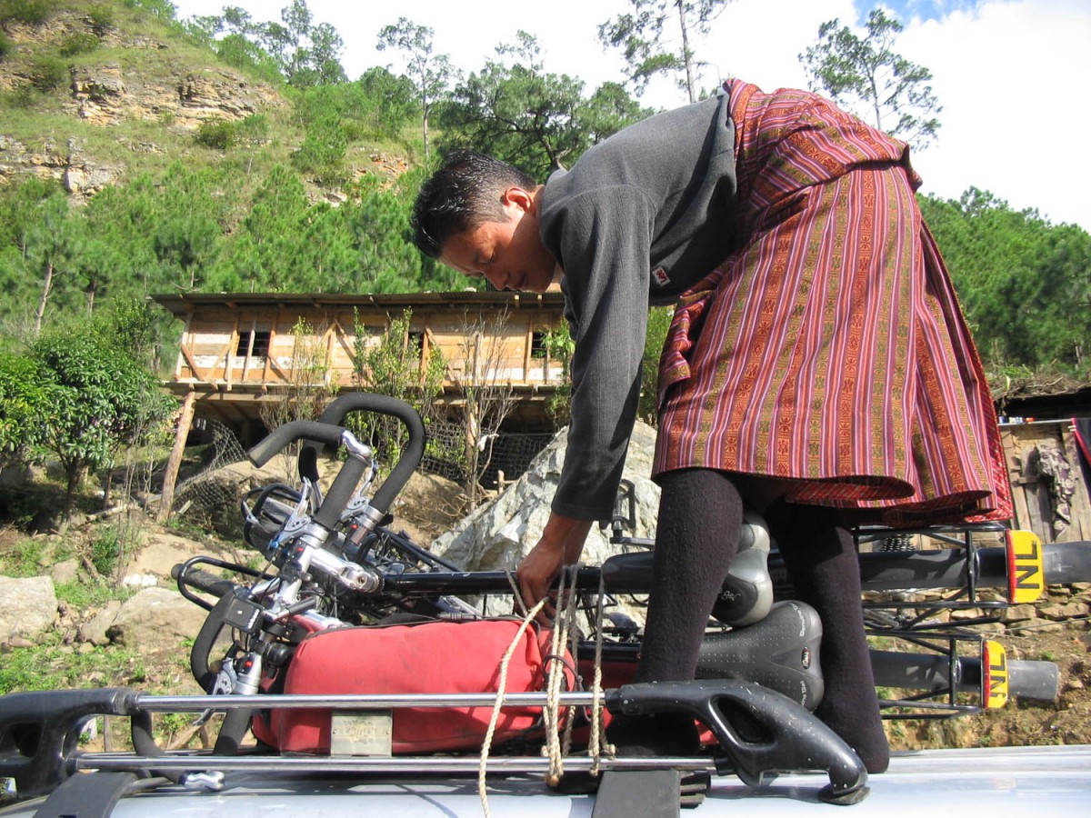 driver Namgay loading bikes on top of car